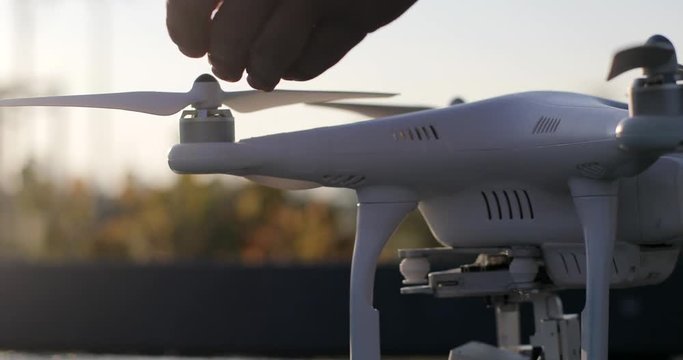 Male hands 4k fixing drone details before flight ready close up nature defocused background. Macro shot man preparing copter flying phantom outdoors autumn. Device gadget quadcopter new technology