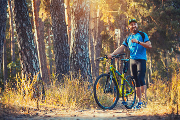Fototapeta na wymiar bearded man cyclist rides in the forest on a mountain bike.