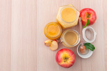 Jewish holiday Rosh Hashanah background with honey and apples on wooden table.