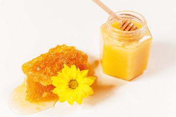jar of honey and stick isolated on white background