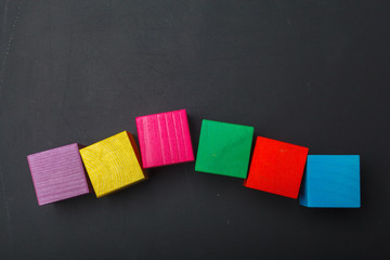 Wooden toy cubes put on blackboard background