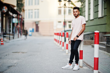 Stylish indian beard man at pink t-shirt. India model posed outdoor at streets of city.