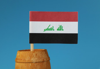 A detail on national flag of Iraq on wooden stick in wooden barrel.
