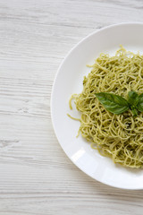 Plate of pasta spaghetti with pesto sauce, overhead. From above, flat lay.