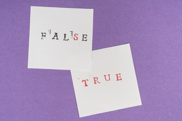 the contrast between the false and true words printed on two sheets of paper