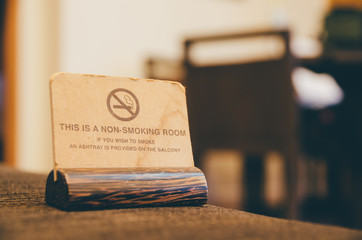 wooden non smoking sign on sofa in room