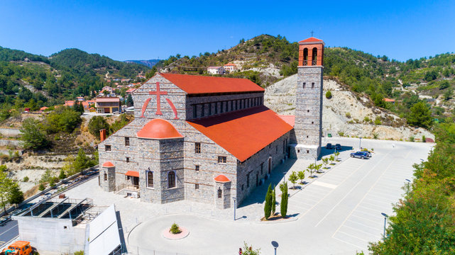 Aerial view of Agios Arsenios church, Kyperounda village, Limassol, Cyprus. Traditional landmark christian greek orthodox, ceramic tiled roof, stone bell tower architecture in Kyperounta from above