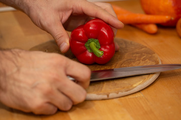 cutting red pepper on wooden board