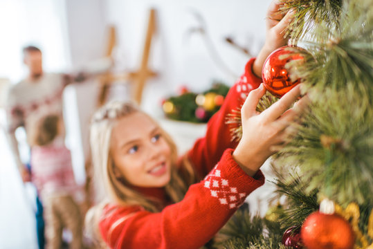 close-up shot of adorble little child decorating christmas tree