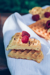 Sweet heart shaped waffles with raspberries for dessert outdoor picnic in the garden.
