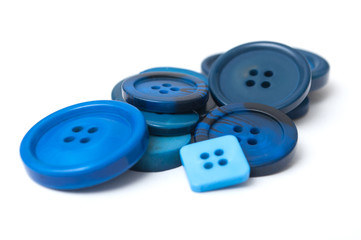 closeup of blue sewing buttons on white background