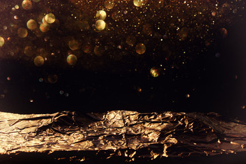 glitter vintage lights background. black and gold. de-focused, golden foil texture.