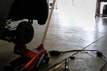brake disc & wheel hub axle heck in auto service. Car lift up for tyre replacement in garage. - obrazy, fototapety, plakaty