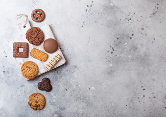Oat and chocolate cookies selection on wooden board on stone kitchen table background. Space for text