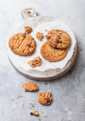 Healthy organic oat cookies with chocolate on wooden board on stone kitchen table background.