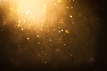 glitter vintage lights background. black and gold. de-focused.