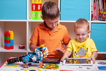 Fototapeta premium Two boys ?hild collects robot from the plastics details