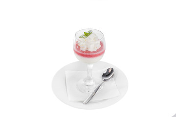 Panna cotta dessert with whipped cream, isolated on a white background in glass with a taste of berries, strawberries, cherries, watermelon, leaf of mint, on a plate with a teaspoon side view for menu