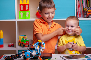 Fototapeta premium Two boys ?hild collects robot from the plastics details