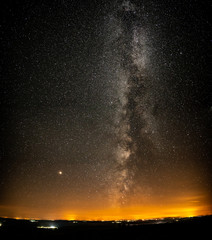 Milky way with many small villages and horizon orange lights