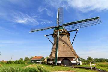 Fototapeta na wymiar Traditional old windmill the 'Moppemolen' in Rijpwetering, the Netherlands, a historic monument and landmark in the dutch landscape on a summer day with a blue sky