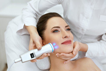 Face Skin Care. Woman Doing Blue Light Therapy At Beauty Clinic