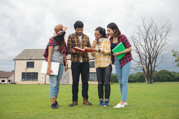 Group Students Smile and have fun It also helps to share ideas in the work and project. And also review the book before the exam outdoor in the garden.