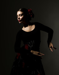 flamenco dancer on a dark background. spanish girl flamenco dancer - obrazy, fototapety, plakaty