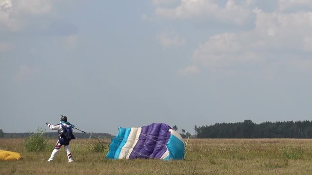 The paratrooper landed on the field, he greets his comrade