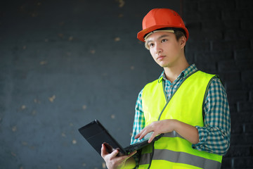 Fototapeta premium Asian man in protective helmet and construction waistcoat