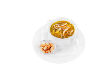 Soup transparent with chicken, fish, noodles in plate isolated white and croutons, dry bread, on a napkin. Serving dishes in a cafe, restaurant, for a menu. Side view