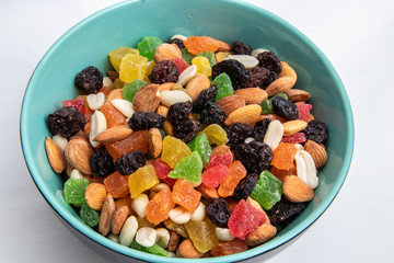 dried fruits and nuts in a green plate on a white background, isolate