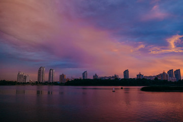 Fototapeta premium View of the city center midtown silhouette from the river at color sunset. text place