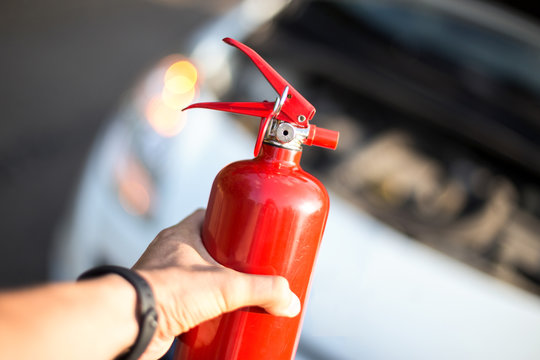 Man With A Fire Extinguisher In His Hand Near The Car