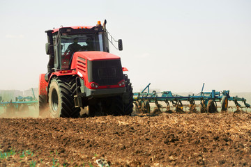 Farmer in tractor preparing land with seedbed cultivator