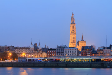 Fototapeta premium Beautiful cityscape of the skyline of Antwerp, Belgium, during the blue hour seen from the shore of the river Scheldt 