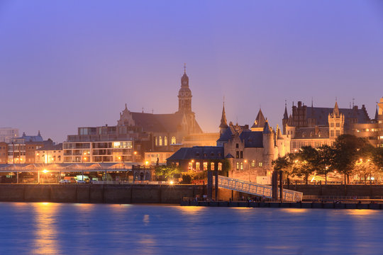 Beautiful cityscape of the skyline of Antwerp, Belgium, during the blue hour seen from the shore of the river Scheldt, with castle Het Steen and St. Paul's Church
