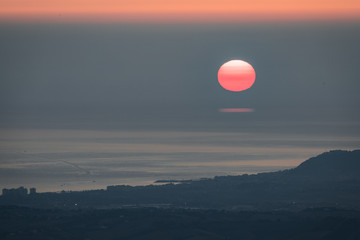 Sun rising over misty sea II