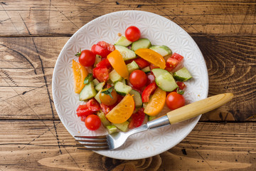 Salad cucumbers with tomatoes on a wooden table.