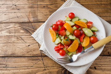 Salad cucumbers with tomatoes on a wooden table.