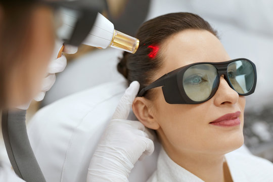 Cosmetology. Woman At Hair Growth Laser Stimulation Treatment