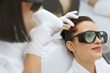 Cosmetology. Woman At Hair Growth Laser Stimulation Treatment