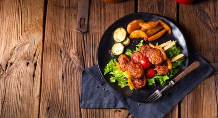 Meatballs skewers of tomato, paprika and baked potato quarters