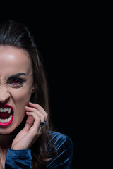 half face portrait of woman showing vampire fangs isolated on black