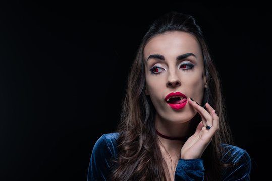 vampire woman touching her tongue isolated on black