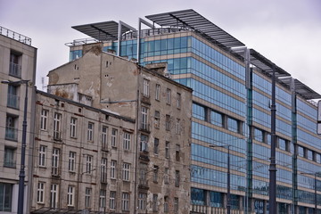 This is a view of contrast of old destroyed tenement house and new modern office. March 27, 2018. Warsaw, Poland.