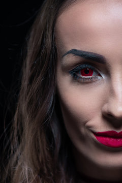 half face portrait of vampire with red eyes isolated on black