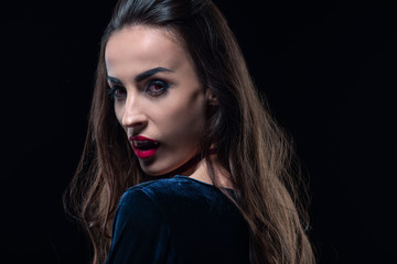 vampire with red lips looking at camera isolated on black