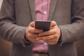 Modern business man using cellphone outdoors.