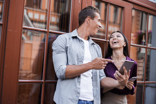 Couple of tourists consulting a city guide and smartphone gps with rouming and new 5g internet in the street searching locations, walk together, love and reletionships, start family